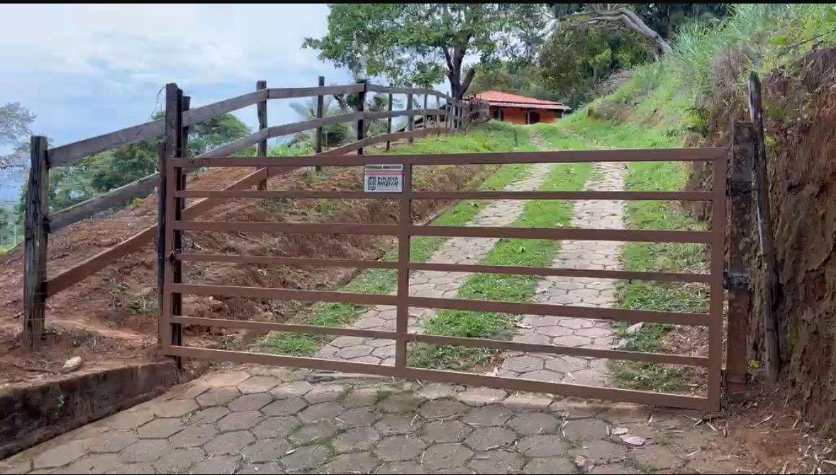 Porteira de entrada do sítio onde o nosso café é plantado, com caminho de pedras subindo até a casa